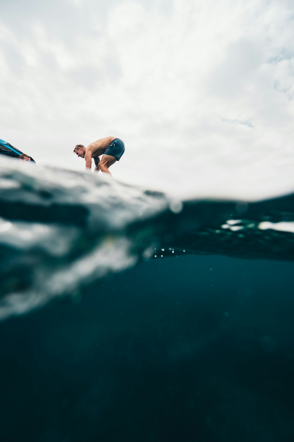 topless man over body of water