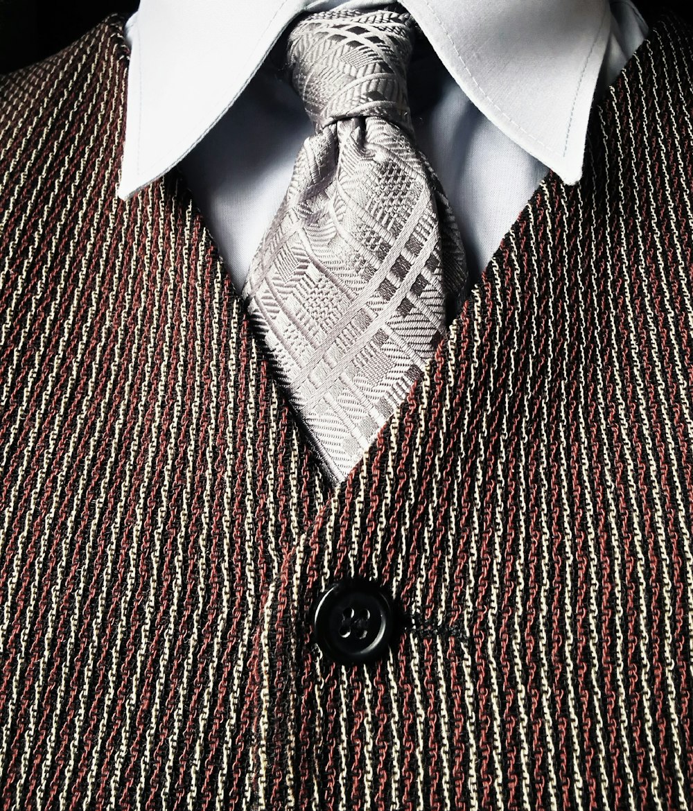 cravatta grigia e gilet abbottonato marrone