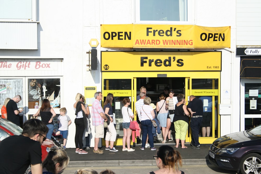 Die Leute stehen Schlange vor Freds Laden