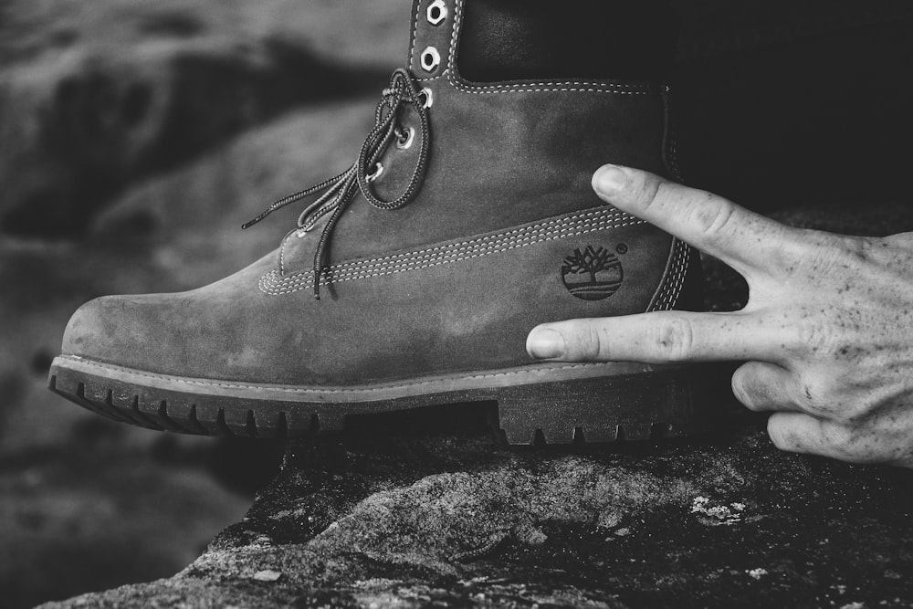 grayscale photography of person wearing Timberland work boot
