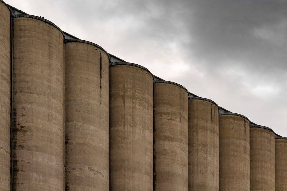 a row of concrete silos against a cloudy sky