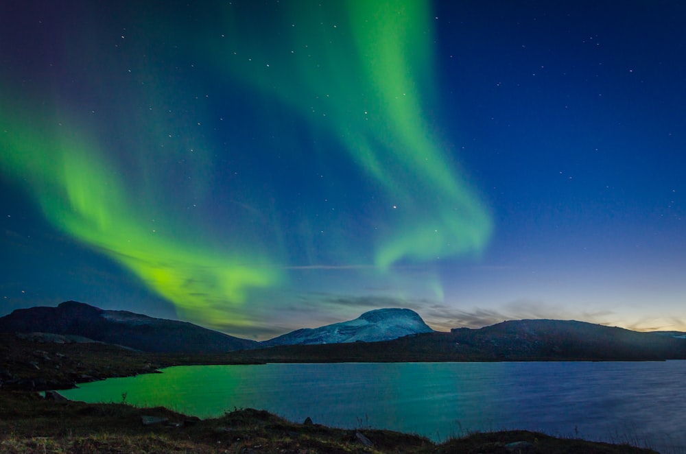 aurora boreale sopra lo specchio d'acqua durante la notte