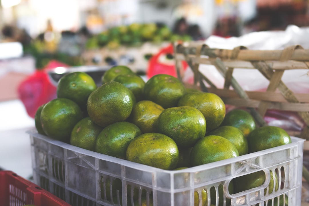green citrus fruits in white crate