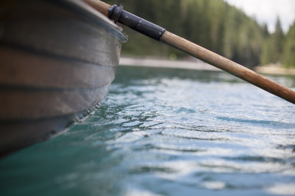 brown row boat on the body of water in closeup photography