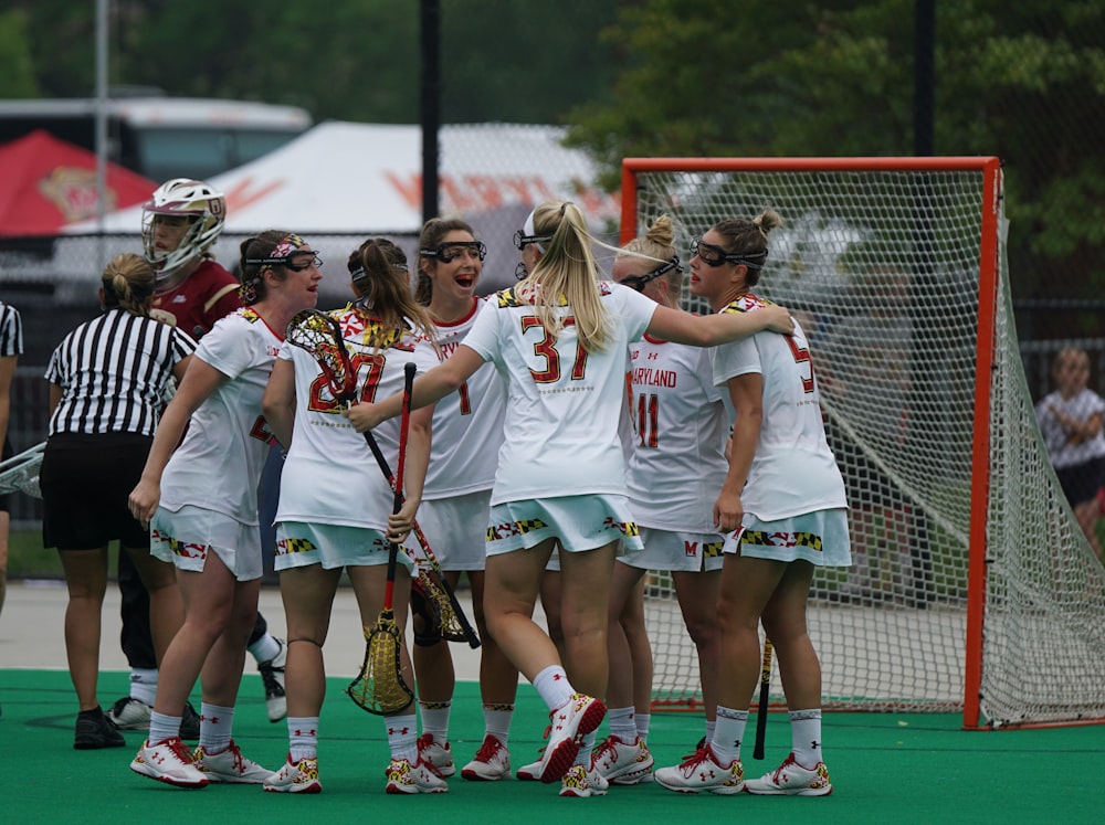 a group of young women standing next to each other on a field