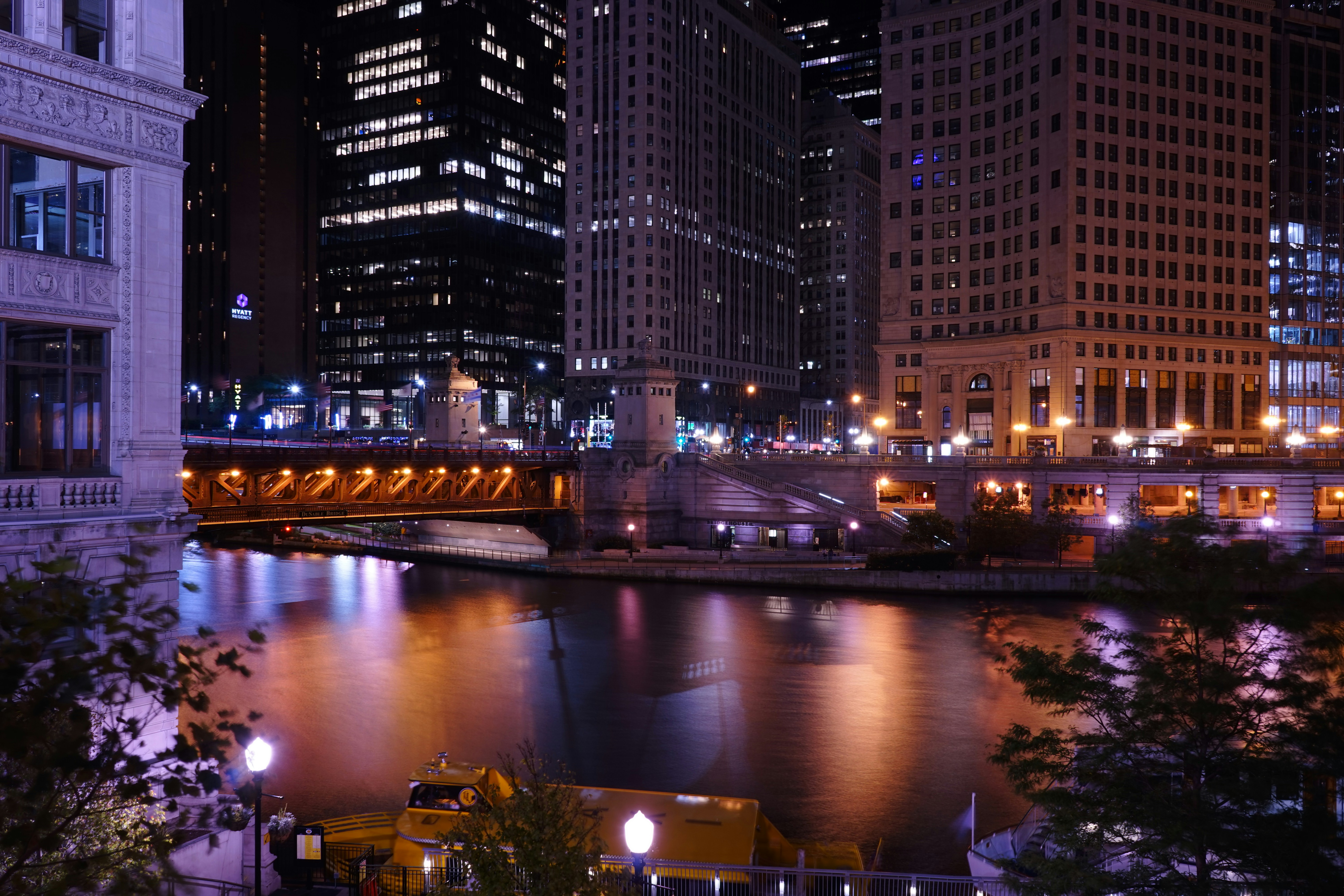Chicago Riverwalk at twilight, with illuminated buildings and bridges - one bedroom chicago