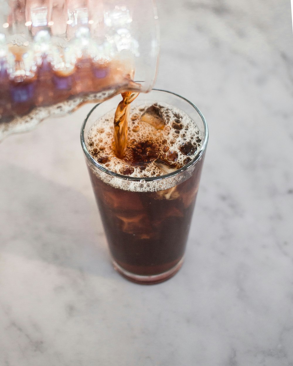 Kalter Kaffee wird in ein Glas eingegossen