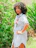 Plus size woman smiling confidently wearing a handmade crochet outfit outdoors.