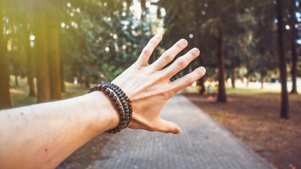 person showing its hand with bracelets