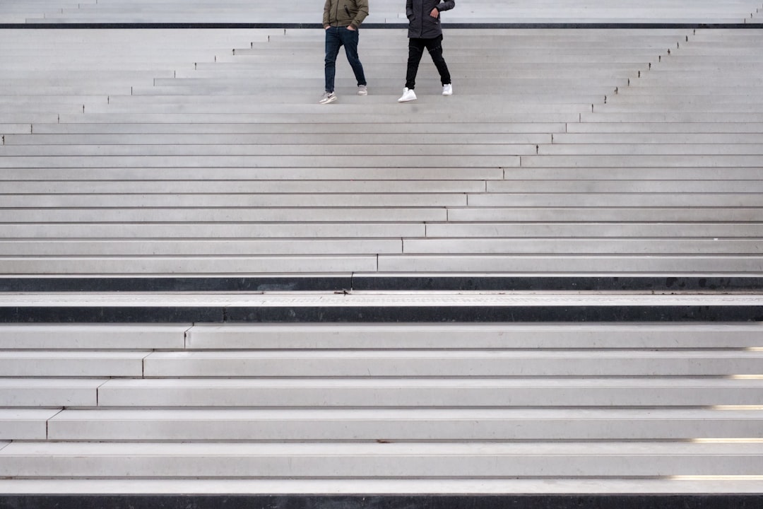 two persons walking through stairs,