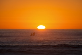 A vibrant sunset view with paddle boards on the water.