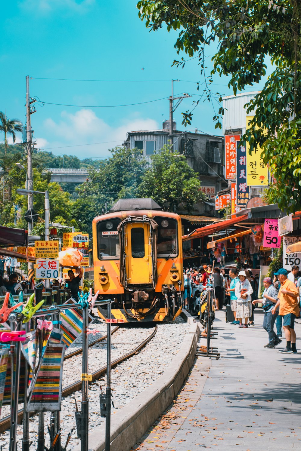 Tren amarillo cerca del edificio y de la gente