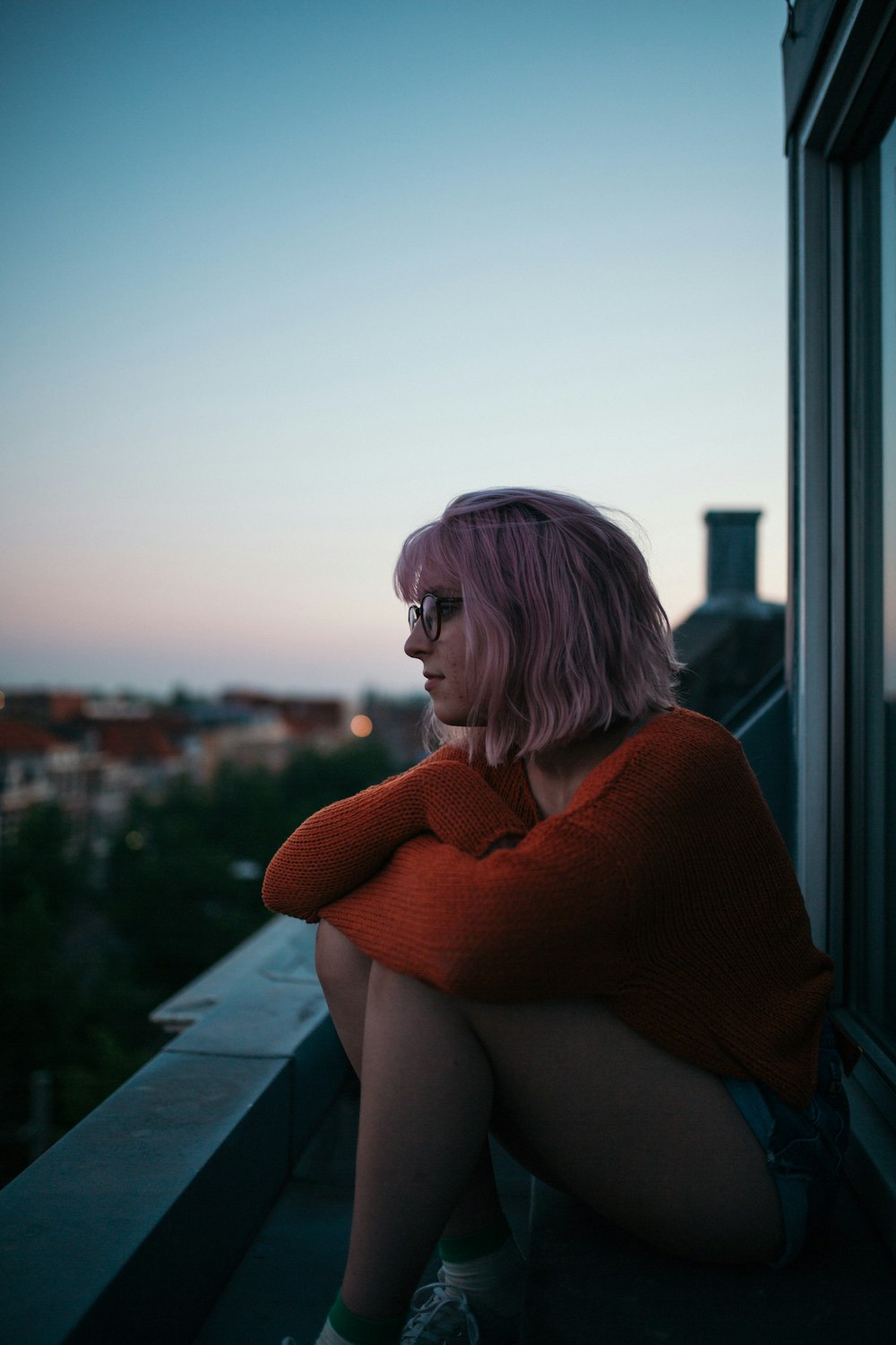 woman sitting near window near building