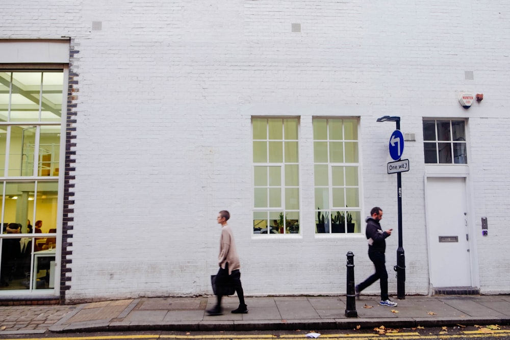 two person walking on side walk