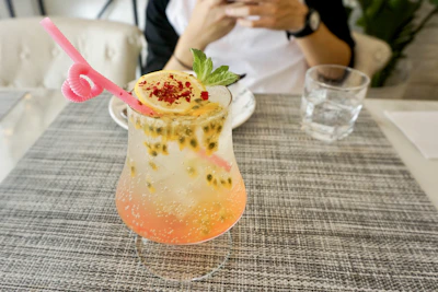 An elegant cocktail glass filled with a colorful, halal-friendly mocktail garnished with fresh fruit.
