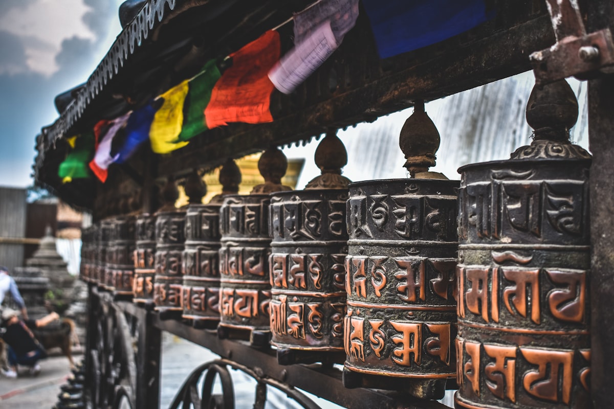 Backpacker walking through a colourful street market in Kathmandu with prayer flags overhead