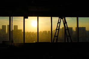 Large window with city skyline view at sunset.