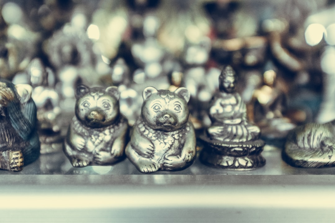 close-up photography of silver-colored bear and Buddha figurines