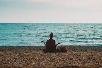 person doing yoga on seashore during daytime