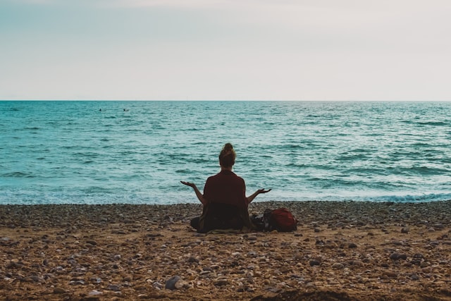Person doing yoga peacefully by the sea