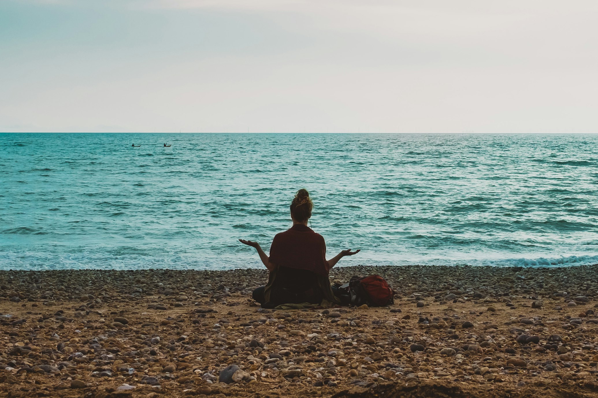 calm woman meditating in front of the sea