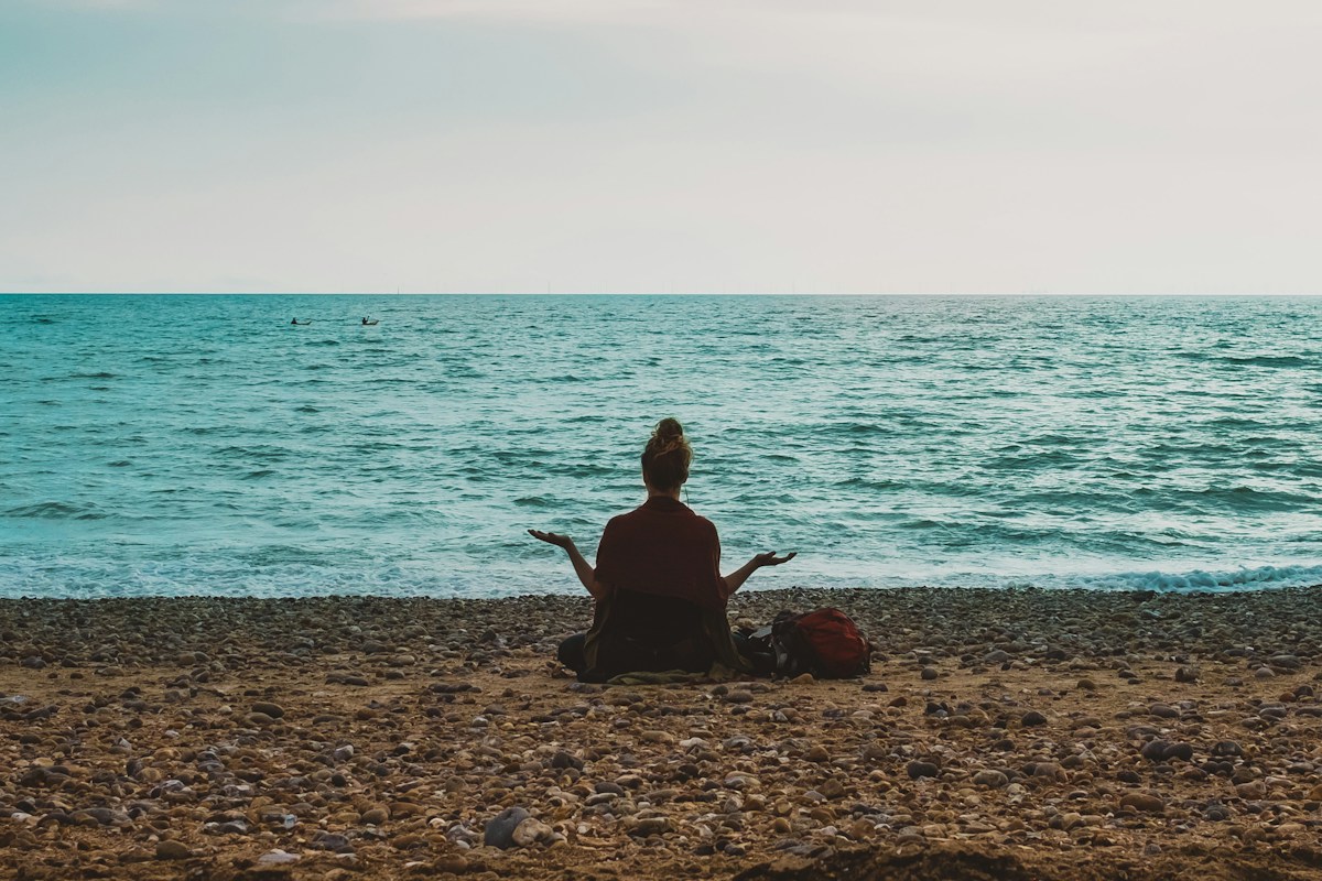 person practicing calm breathing outdoors by the sea