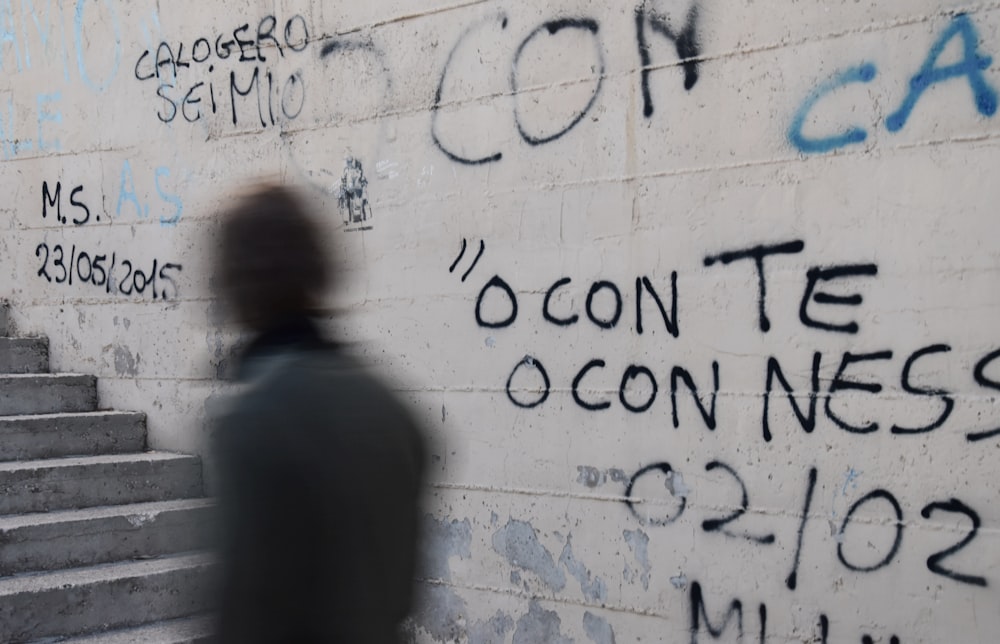 person standing near white painted wall