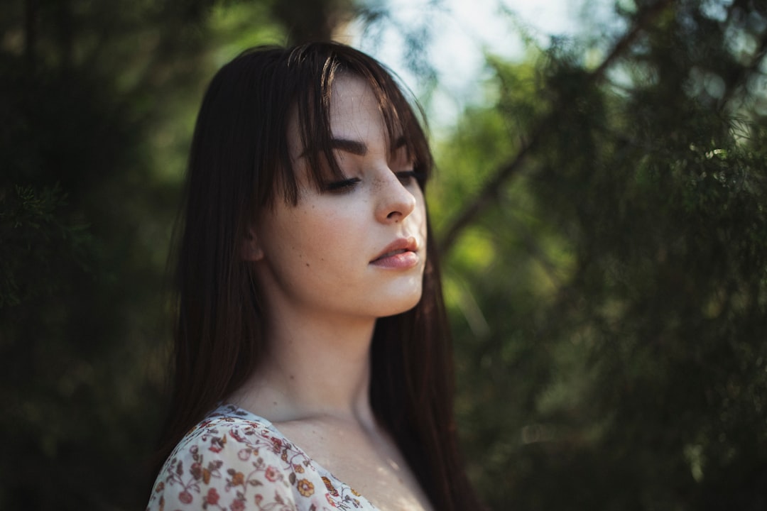 selective focus photography of woman standing infront of plants