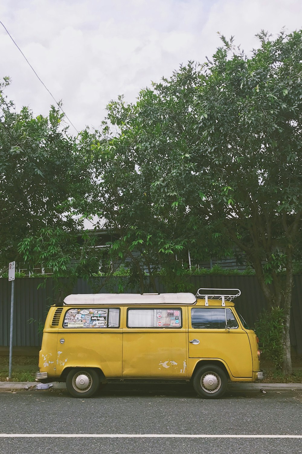 木の近くに駐車された黄色いバン