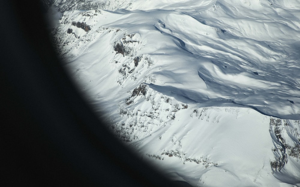 낮에 눈 덮인 산의 항공 사진