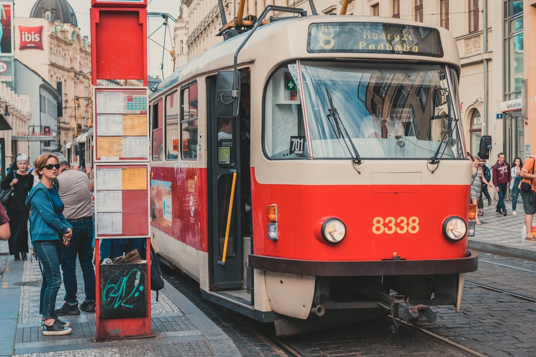 people near red and white tram