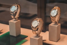 three round silver-colored chronograph watches on white mounts