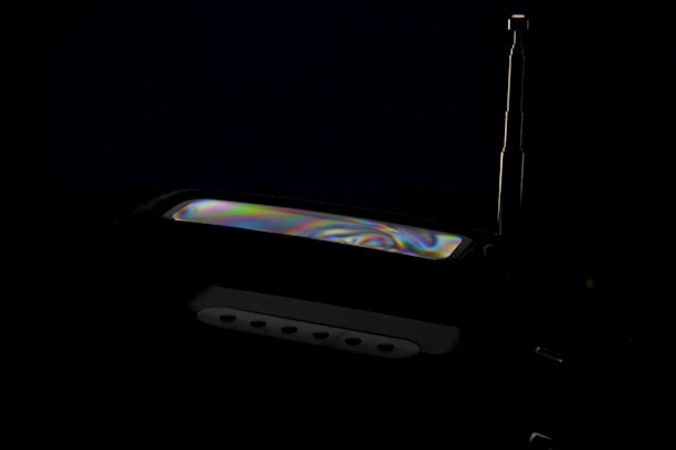 A close-up of a homemade antenna setup glowing softly under green and amber radio signal lights.