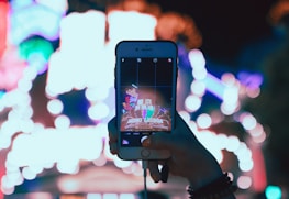 An influencer filming engaging content with bright neon city lights in the background.