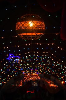 An evening scene of a sleepover setup with soft glowing lanterns and a starry sky overhead, inviting warmth and wonder.