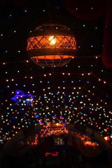 A hanging patio lantern glowing warmly during a twilight garden gathering.