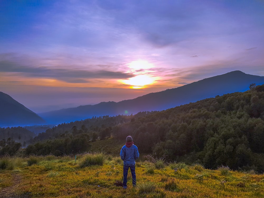 person standing on hill during golden hour