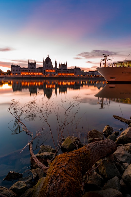 white and black boat on body of water in Hungarian Parliament Building Hungary