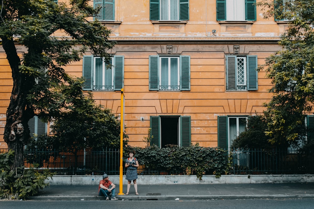 woman standing beside yellow post during daytime