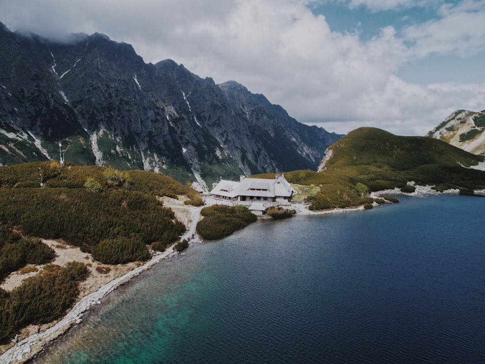 gray bungalow house on mountain near body of water