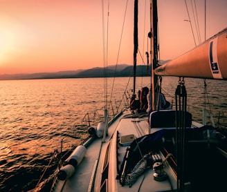 white and black sailboat during sunset