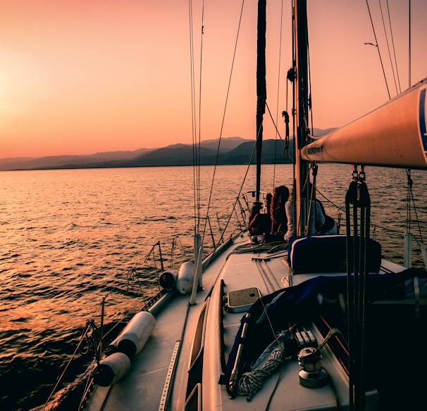 white and black sailboat during sunset