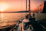 white and black sailboat during sunset