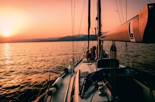 white and black sailboat during sunset
