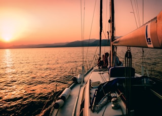 white and black sailboat during sunset