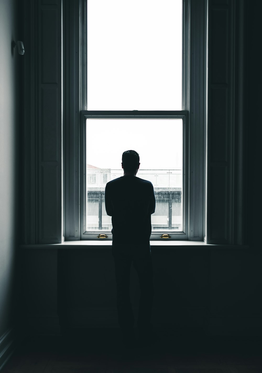 silhouette of person standing in front of window at daytime