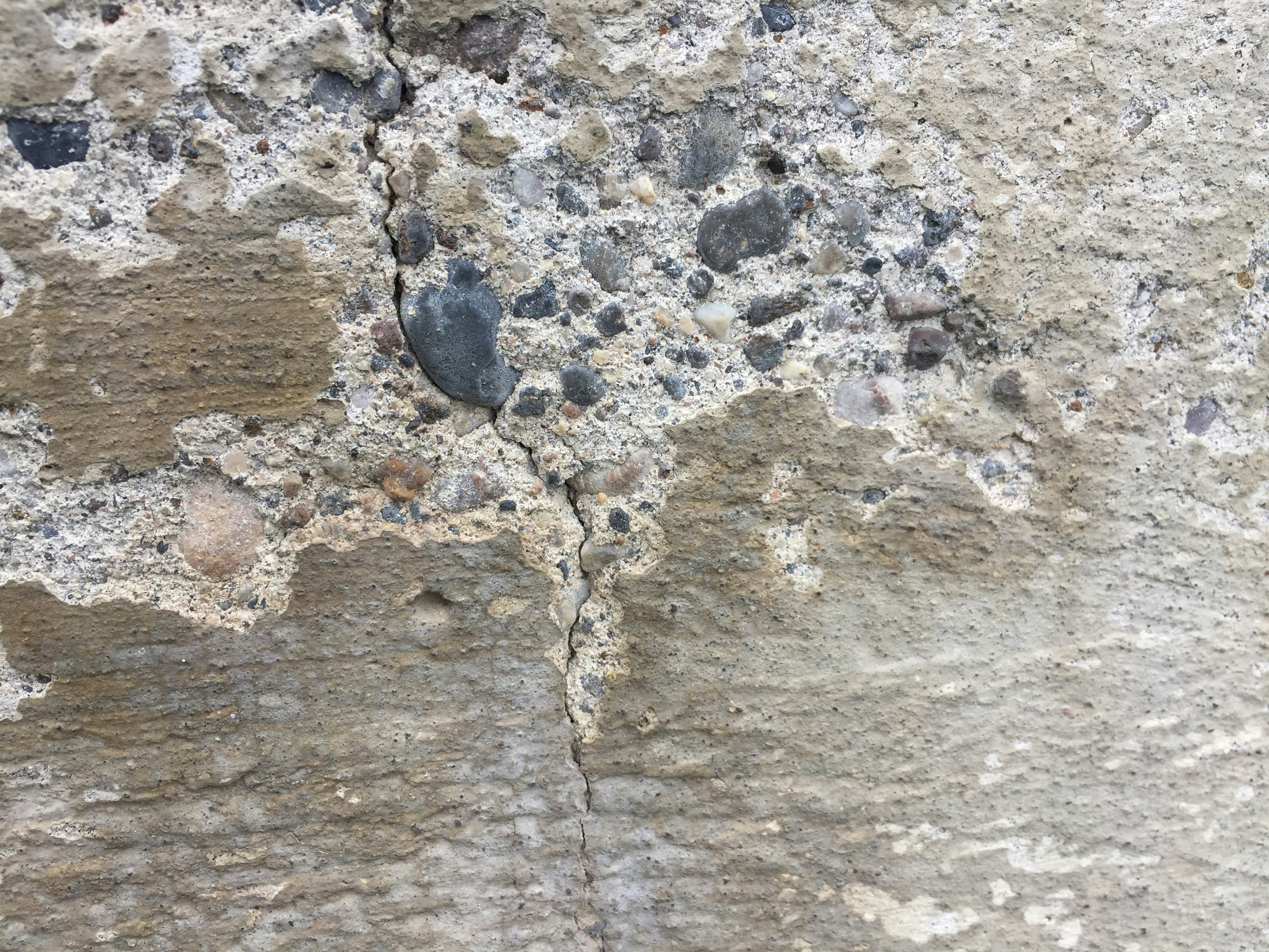 Close-up of a cracked concrete wall showing signs of structural damage.