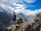 man standing on top of mountain beside cairn stones