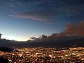 Cloud network connections illustrated over a cityscape at dusk.