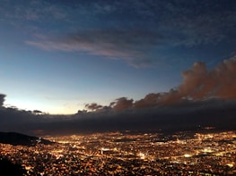 Cloud network connections illustrated over a cityscape at dusk.